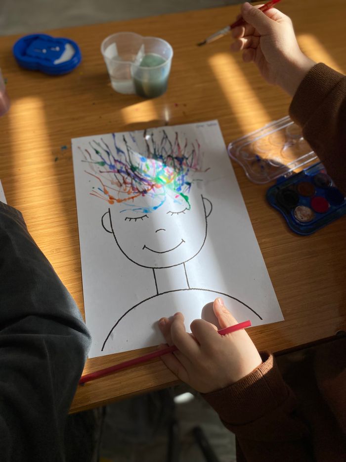 Children painting colorful abstract art with watercolors on paper.